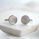 Pair of silver fingerprint cufflinks on a white surface